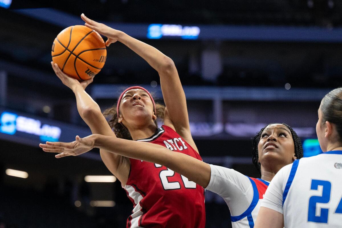 The McClatchy Lions’ Nina Cain (22) is fouled by the Folsom Bulldogs’ Avery Masters (4) in the first half in the Sac-Joaquin Section Division I girls basketball championship.