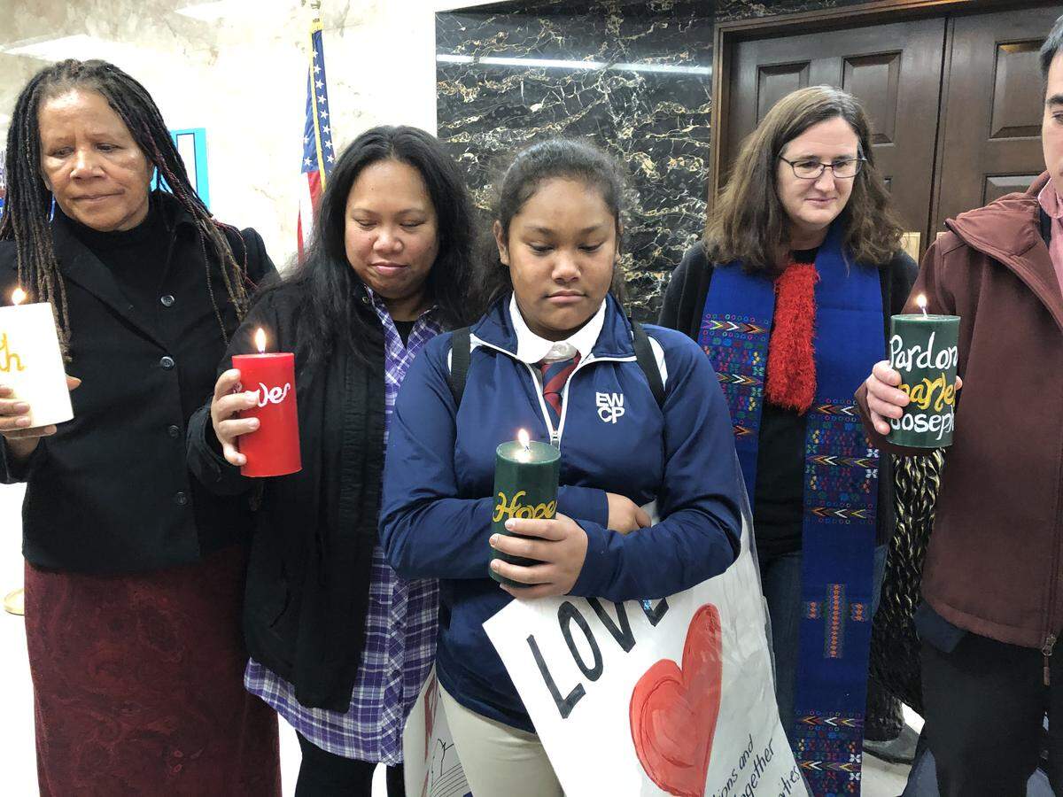 From left, Charles Joseph’s mother, Alumita Siva; wife, Shelly Clements; and 12-year-old daughter, Hope Joseph, and others take part in a vigil at California Gov. Gavin Newsom’s office Dec. 19.