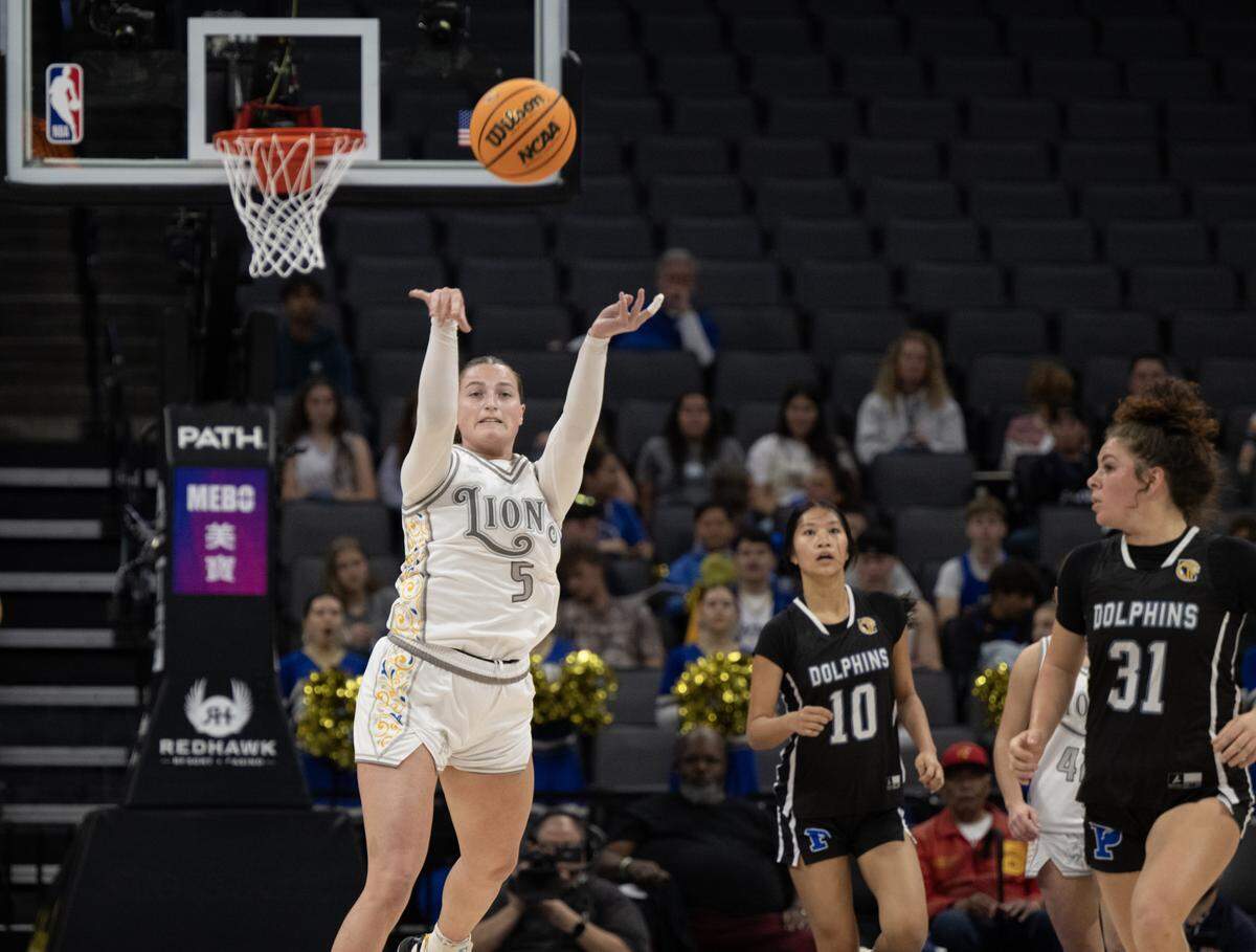 The Faith Christian Lions' Lauren Harris (5) scores from behind the half court line at the end of the first quarter against the Palisades Dolphins in the CIF State Division IV girls basketball championship Friday, March 14, at Golden 1 Center in Sacramento.