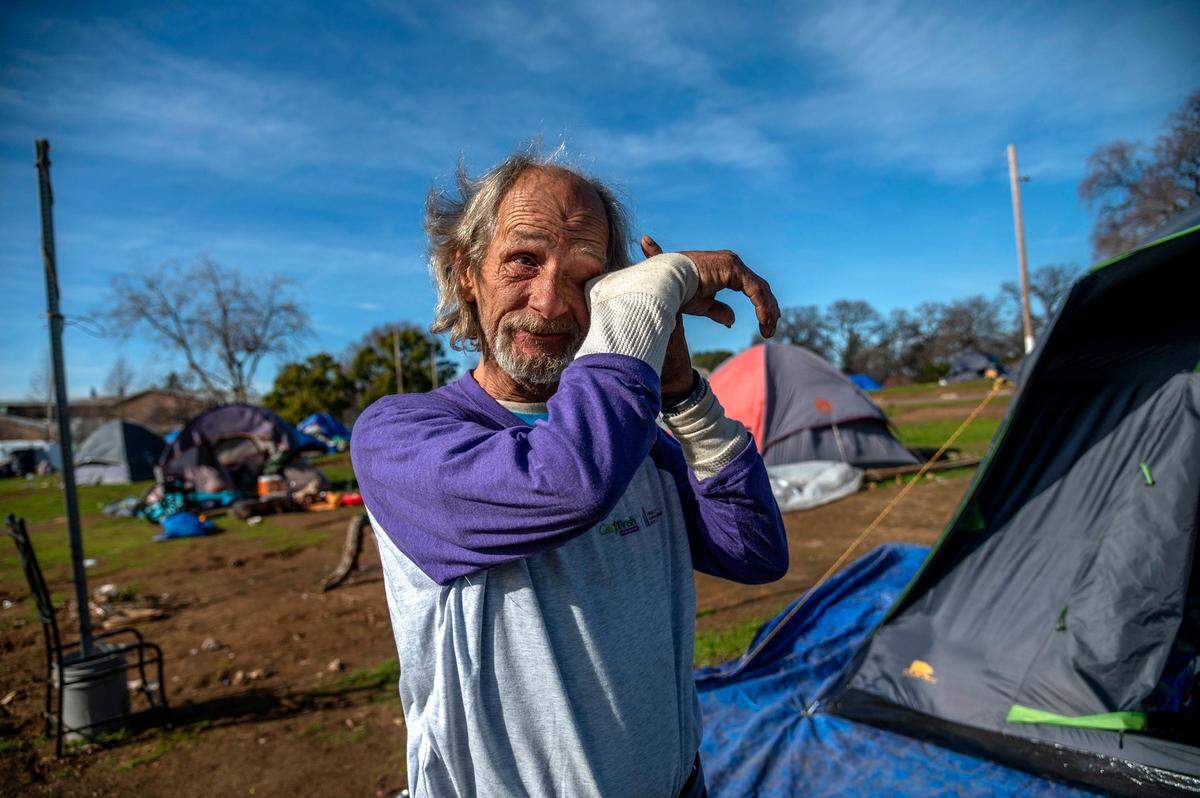 Roy Warren, 63, wipes tears as he explains how he is in on a fixed income, suffers seizures, and can’t work or drive Jan. 21, at a homeless encampment in Auburn. He says he feels stuck with no place to go.