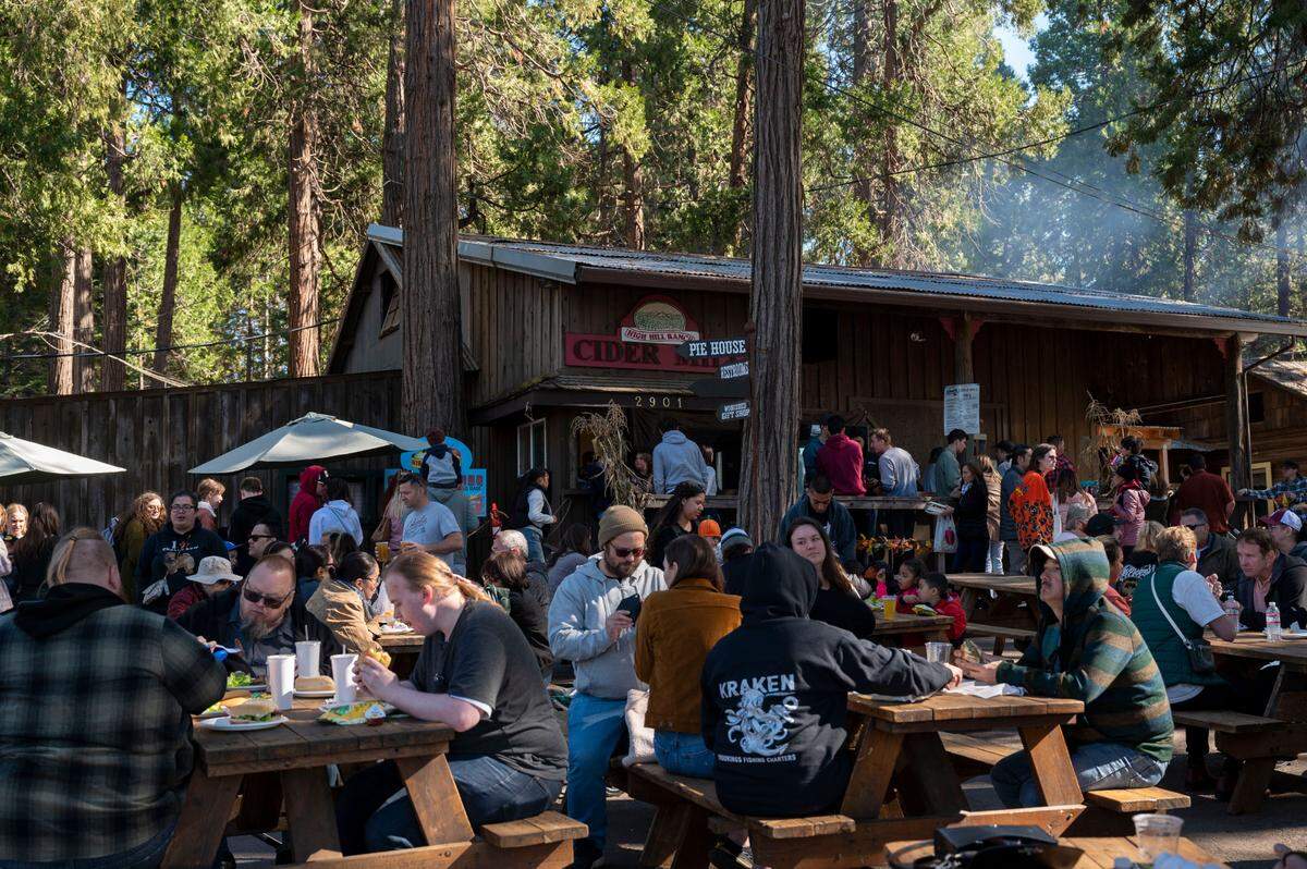 People sit outside one of the barns at High Hill Ranch on Saturday at Apple Hill.