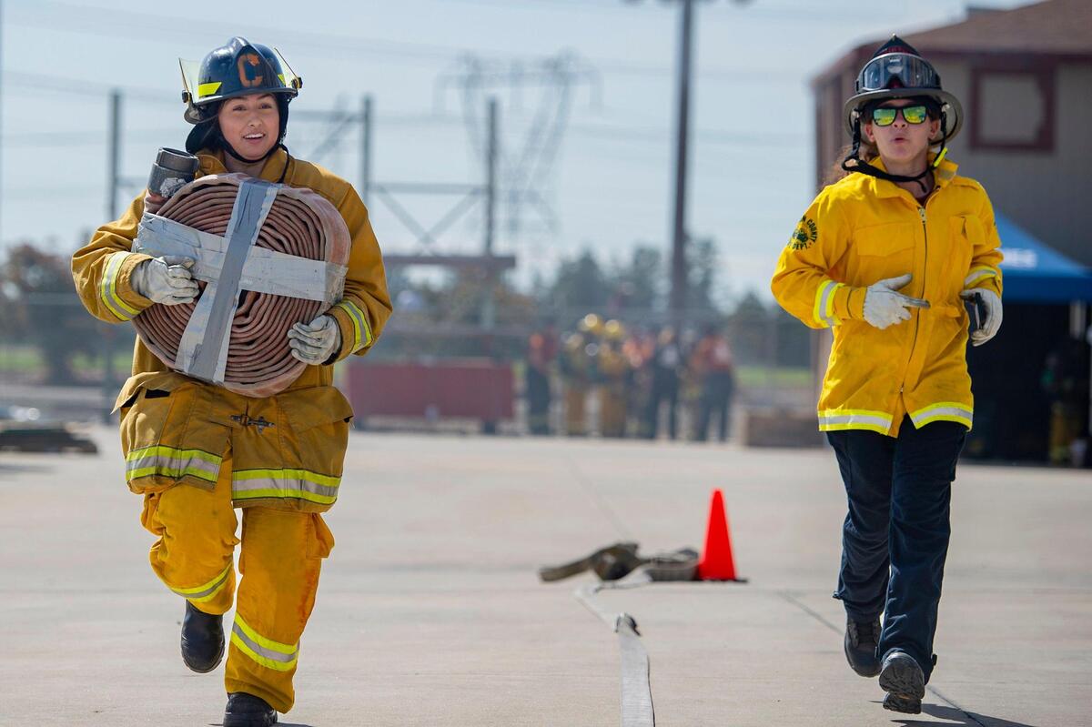Erika Yepes, 16, runs with a hose weighing about 25 pounds. with Bella DeRuvo of the Marin Fire Department, right, during the physical ability test station at the HERo Girls Fire Camp, hosted by the Cosumnes Fire Department, on Sunday.