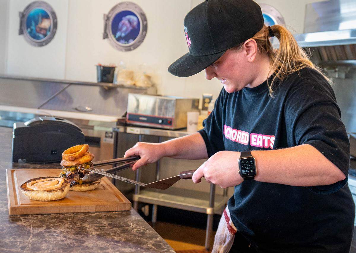 Anchored Eats co-owner Ruby Shields puts together the Yeehaw Burger on Thursday, June 15, 2023.