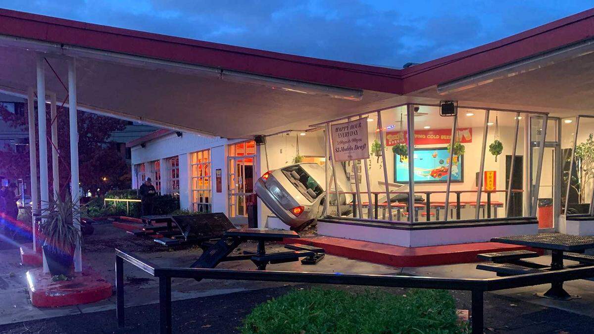 A car is seen wedged near the entrance to Suzie Burger on 29th and P streets in midtown Sacramento on Monday, Dec. 12, 2022. The driver of the vehicle was hospitalized and the cause of the crash was unknown.