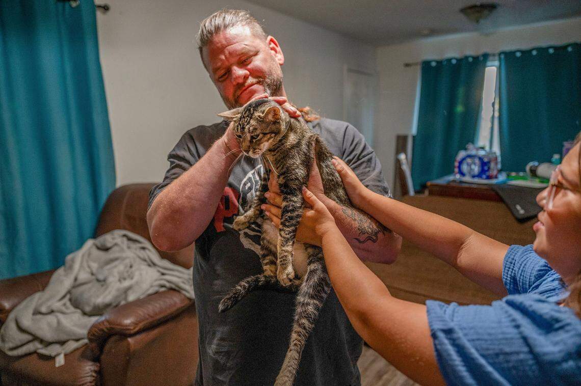 Seth Jordan and his daughter Lennox, 10, care for his son Shawn Jordan’s cat Razzle on Aug. 21. The cat is now living with them after Shawn died five days after being hit by a car along Walerga Road in June.