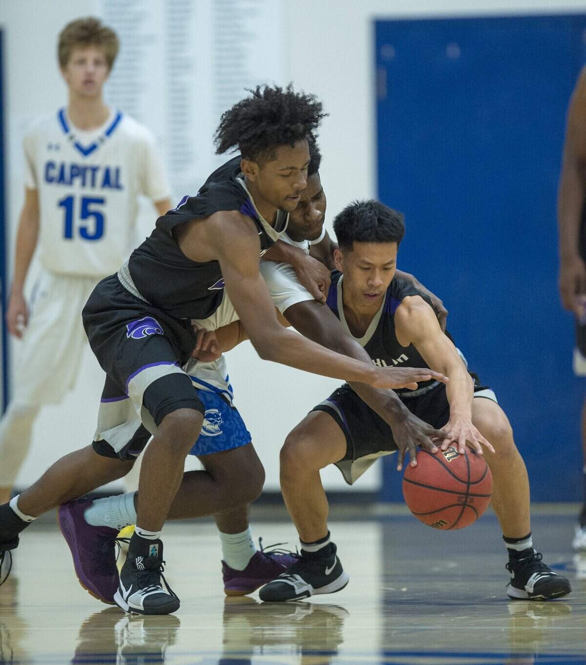 Franklin forward Keilen Valdry, left, and guard Raymond Sim, right, force Capital Christian's Damion Malott Jr. into a turnover during the Sac-Joaquin Section Division I playoffs second round on Feb. 23 in Sacramento.