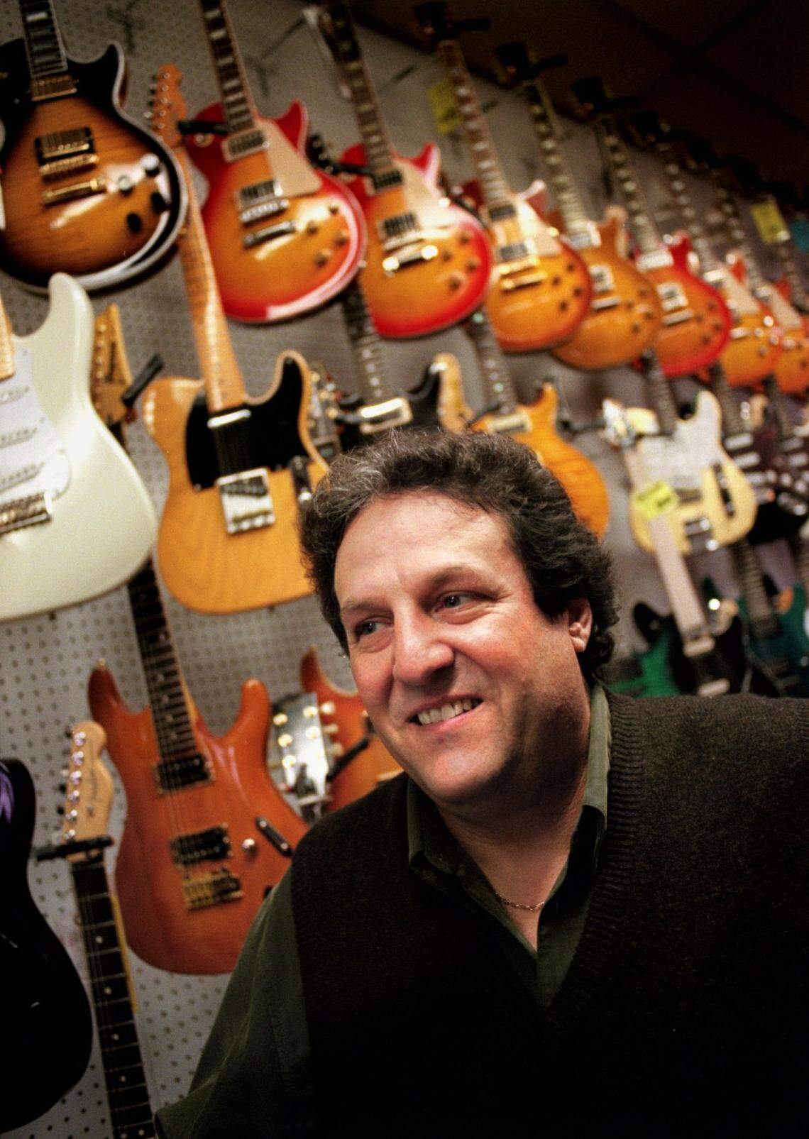 Skip Maggiora, owner of Skip’s Music, stands in front of a wall of guitars at his Auburn Boulevard store in 1998.