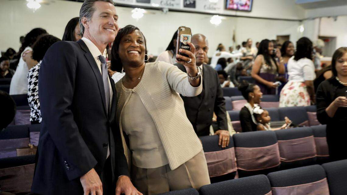 California democratic candidate for governor, Lt. Gov Gavin Newsom, takes a selfie with Laphonza Butler, president of SEIU local 2015, before speaking at Greater Zion Church in Compton on June 3, 2018.