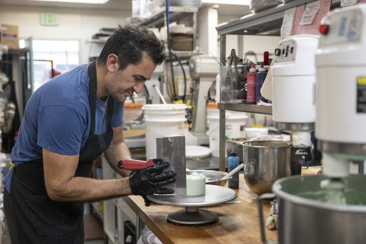 A worker prepares small bento cakes at Rick’s Dessert Diner in midtown Sacramento on Tuesday. Rick’s currently employs at least 35 workers.
