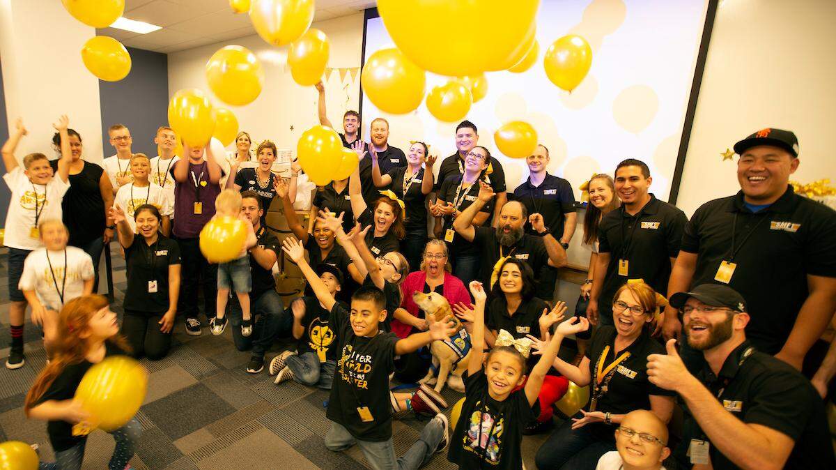 Associates and guests pose for  photo at the Amazon Goes Gold event at SMF1, the Amazon Fulfillment Center in Sacramento, Calif., Wednesday, Sept. 19, 2018.
