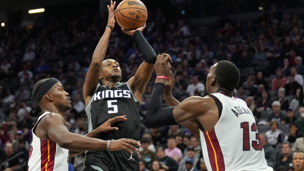 Sacramento Kings guard De’Aaron Fox (5) shoots against Miami Heat forward Jimmy Butler (left) and center Bam Adebayo (13) during the fourth quarter Oct. 29, 2022, at Golden 1 Center.