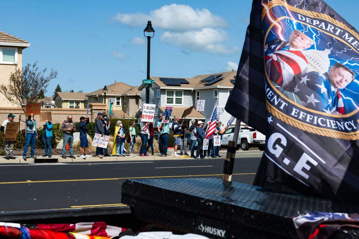 A convoy of Trump supporters drives past anti-Tesla  demonstrators on Granite Drive in Rocklin near the Tesla dealership on Saturday, March 29, 2025.