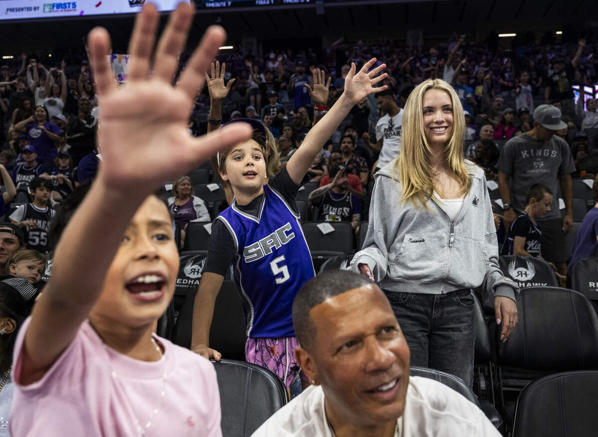Dutch Newsom, Gov. Gavin Newsom’s youngest son, center, puts his hand up as he attempts to catch a ball at Golden 1 Center during a Sacramento Kings game on Sunday. His sister Montana stands with him at right.