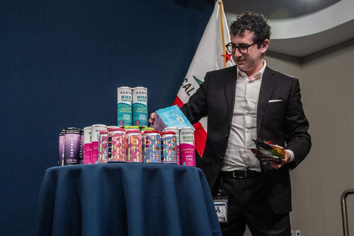 Izzy Gardon, deputy director of communications for Gov. Gavin Newsom, builds a display of locally purchased intoxicating hemp products, which the governor said are marketed to children, before a press conference in Sacramento on Friday.