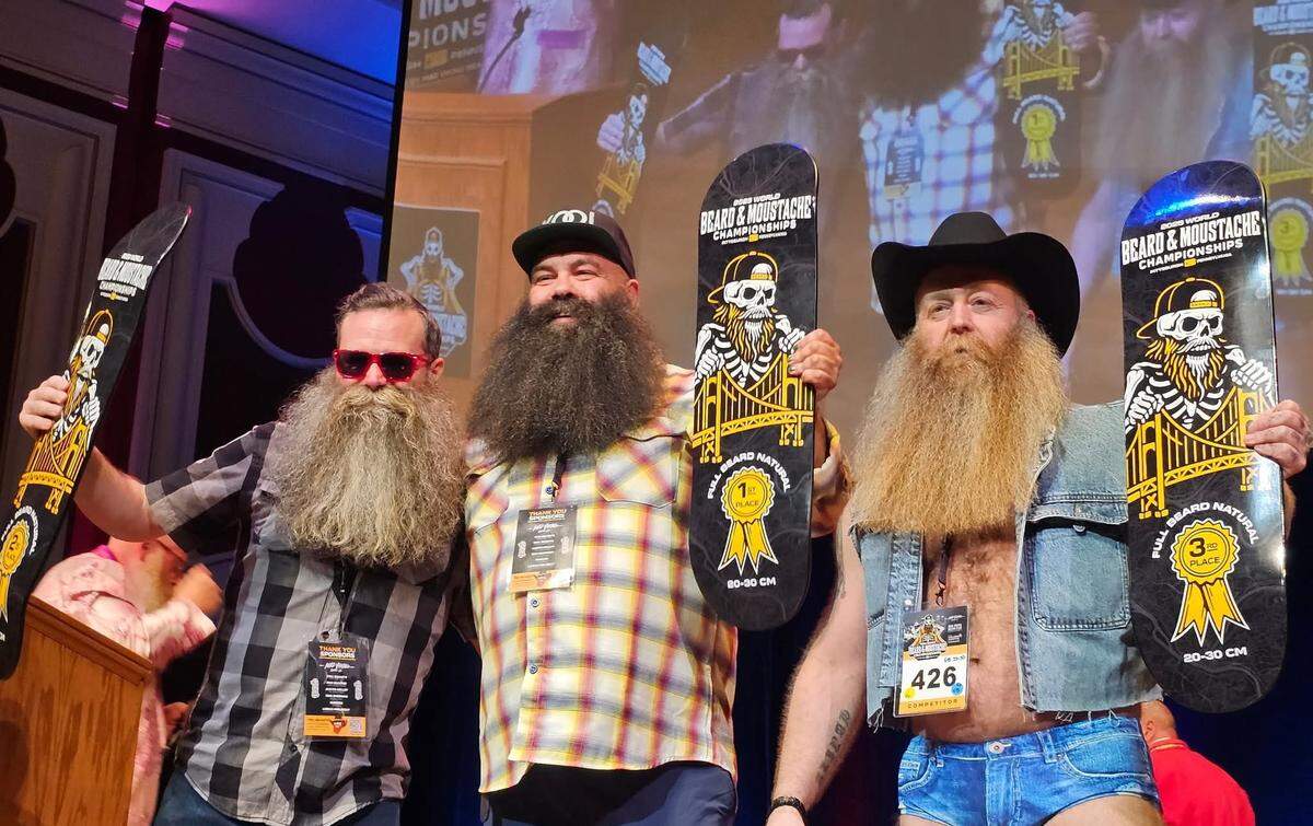 Sacramento native Trevor Mustafa, center, celebrates his win in the natural beard 20-30 centimeter category at the 2025 World Beard and Moustache Championships in Pittsburgh. He would later take home the best in show award over roughly 30 division winners.