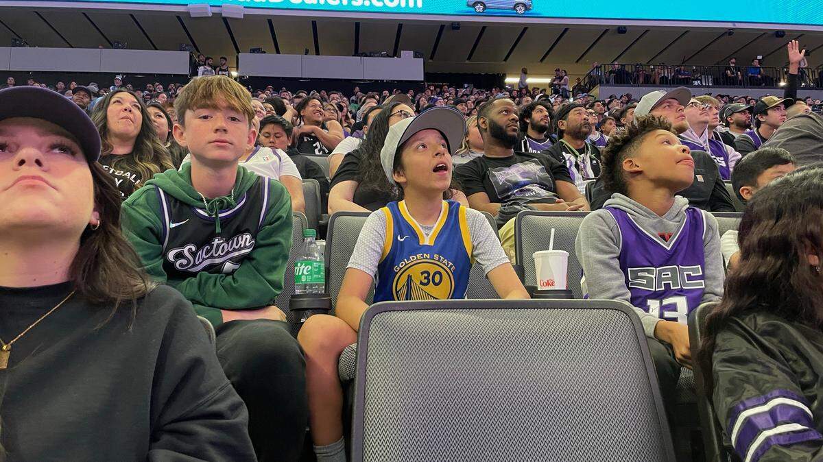 Sacramento Kings Ethan Whipple, 13, watches the big screen with friend Joey French, 12, a Golden State Warriors fan, at the Game 3 watch party at Golden 1 Center on Thursday, April 20, 2023.