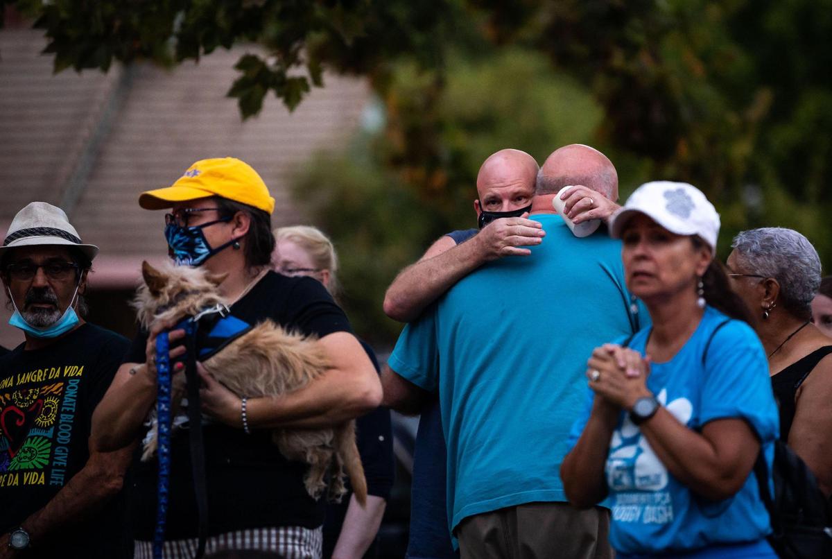 Casey Tibbitts, center, embraces his brother, Dan Tibbitts, during a vigil for their sister, Kate Tibbitts, at Plaza Cervantes Park on Thursday, Sept. 9, 2021, in Sacramento’s Land Park neighborhood. Tibbitts and her two dogs, Molly and Ginny, where found slain in their 11th Avenue home on Sept. 3.