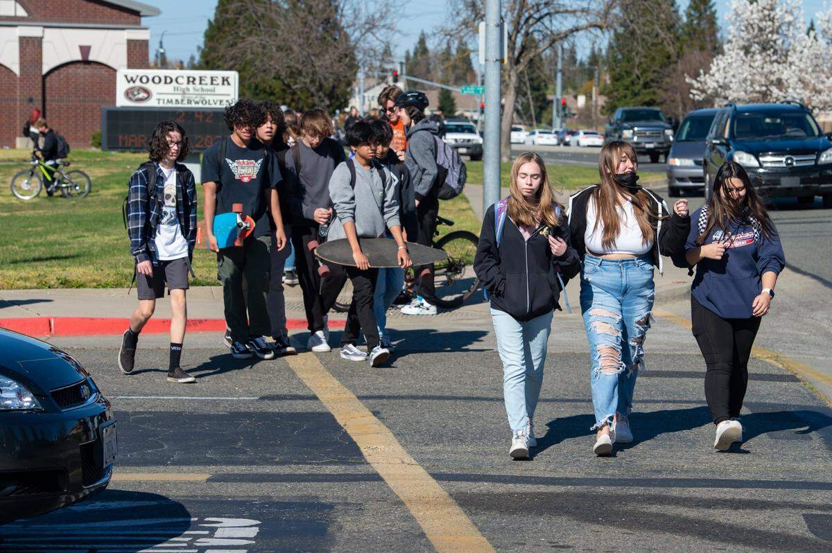 Students exit Woodcreek High School in Roseville at the end of the school day Monday. The Roseville Joint Unified High School District voted in February to stop enforcing the statewide health order requiring masking in schools.