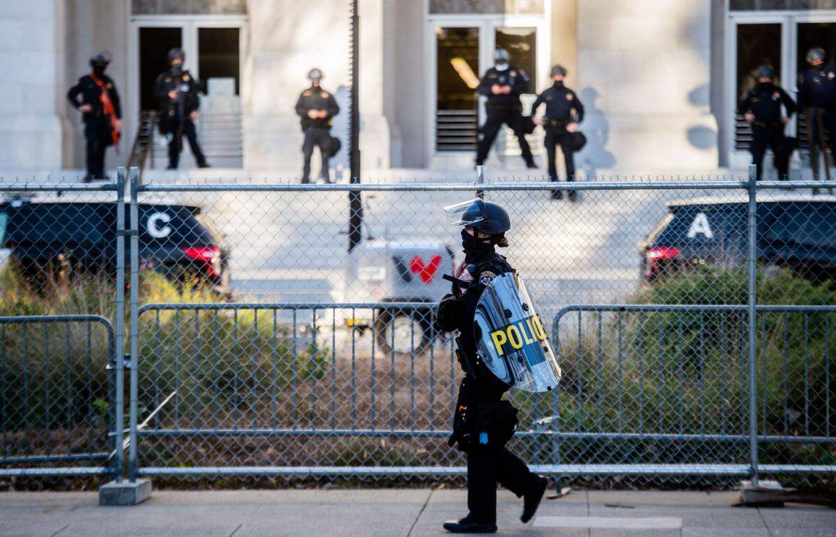 A California Highway Patrol officer holds a shield as she walks near the Capitol in Sacramento on Inauguration Day in 2021.
