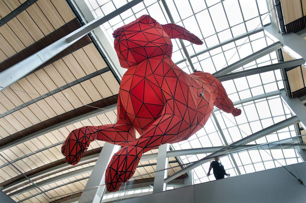 The 56-foot-long, 15-foot diameter “Leap”, a red rabbit made of steel and aluminum by Denver artist Lawrence Argent, hangs from cables inside Terminal B at Sacramento international Airport in 2011.