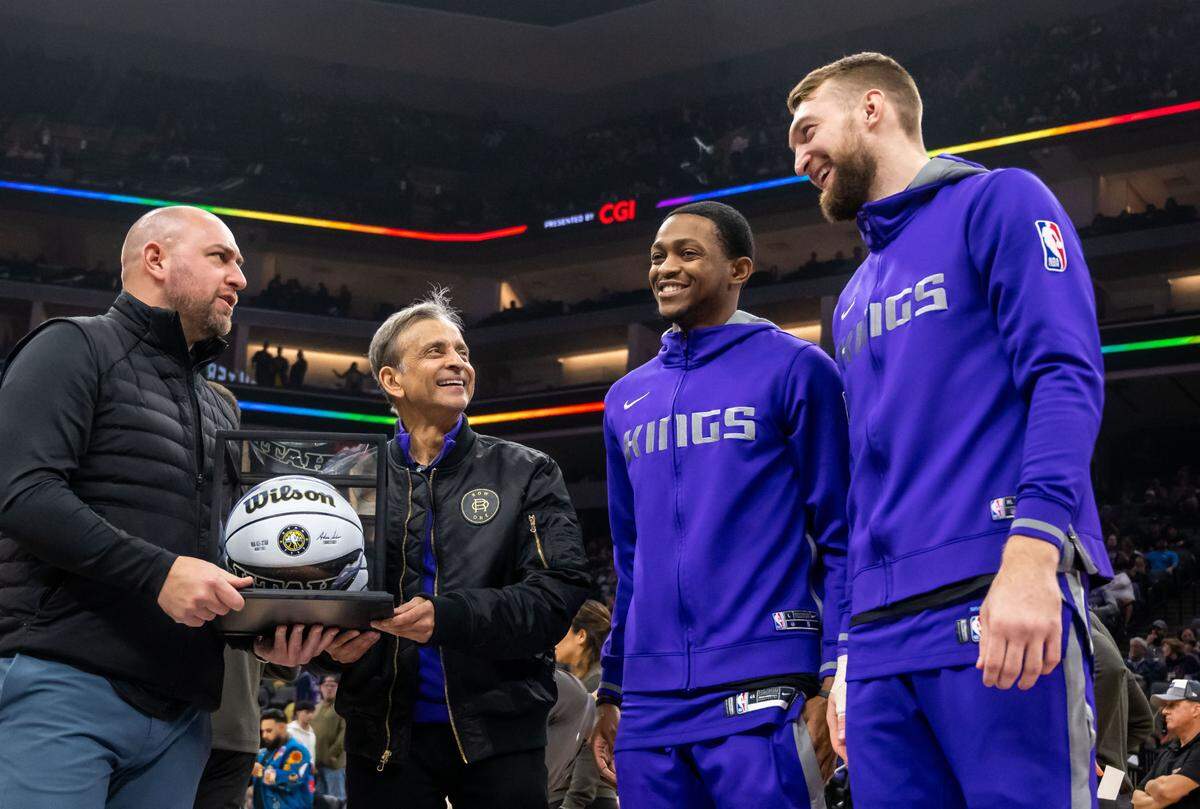 Sacramento Kings guard De’Aaron Fox (5) and center Domantas Sabonis (10), right, are presented with an all-star ball by manager team owner Vivek Ranadivé and general manager Monte McNair, left, before the Kings’ overtime NBA basketball win against the Dallas Mavericks on Saturday, Feb. 11, 2023, at Golden 1 Center in Sacramento.