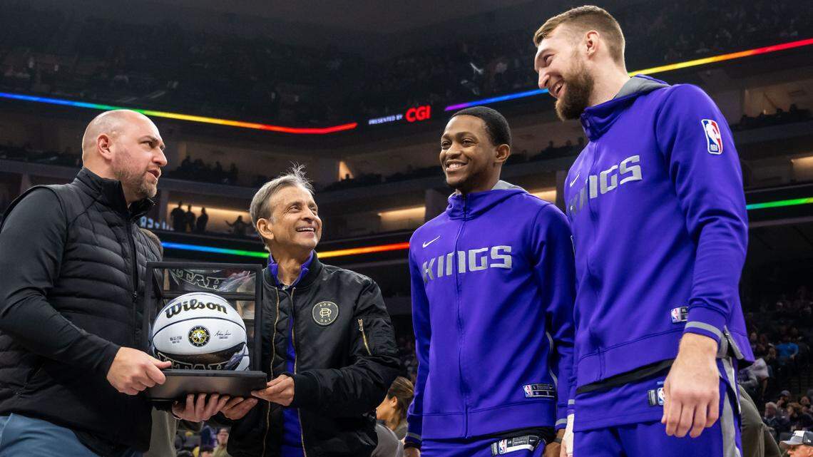 Sacramento Kings guard De’Aaron Fox (5) and center Domantas Sabonis (10), right, are presented with an All-Star ball by team owner Vivek Ranadivé and general manager Monte McNair, left, before the Kings’ overtime NBA basketball win against the Dallas Mavericks on Saturday, Feb. 11, 2023, at Golden 1 Center in Sacramento.