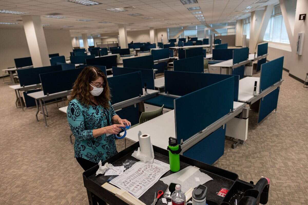 Petra Voigt of Sutter Health prepares surfaces that are already sanitized in preparation for opening a pop-up COVID-19 vaccination clinic in Roseville on Friday, Jan. 29, 2021.The center will begin giving vaccinations Monday by appointment only for Sutter patients over age 85.