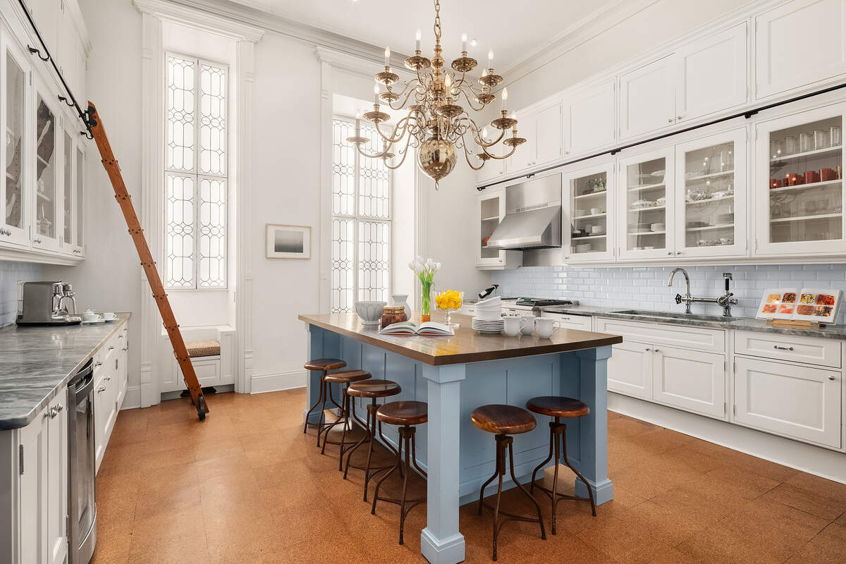 Fourteen-foot ceilings and a fun and practical rolling ladder are found in the kitchen.