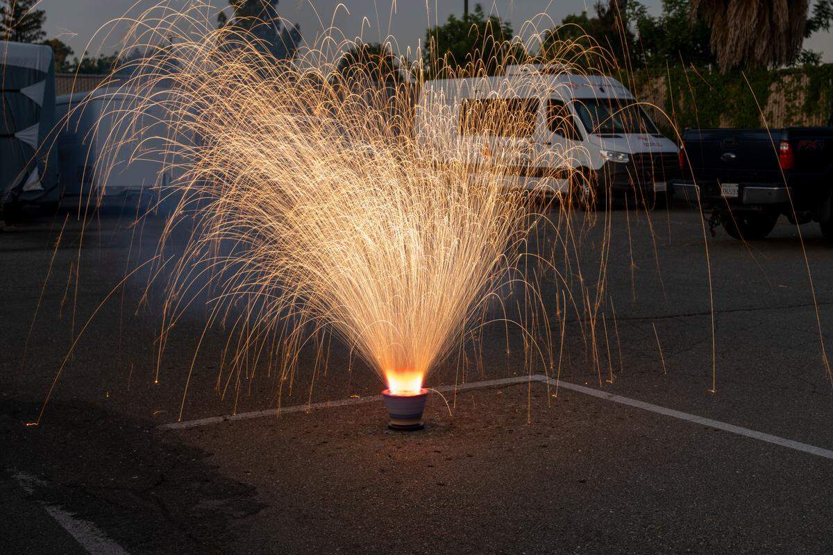 TNT Fireworks’ American Revolution box spins while shooting multi-colored lights through the air in the parking lot of Sacramento Fire Department Station 19 on Thursday, June 19. It produces blue sparks, which require cobalt.