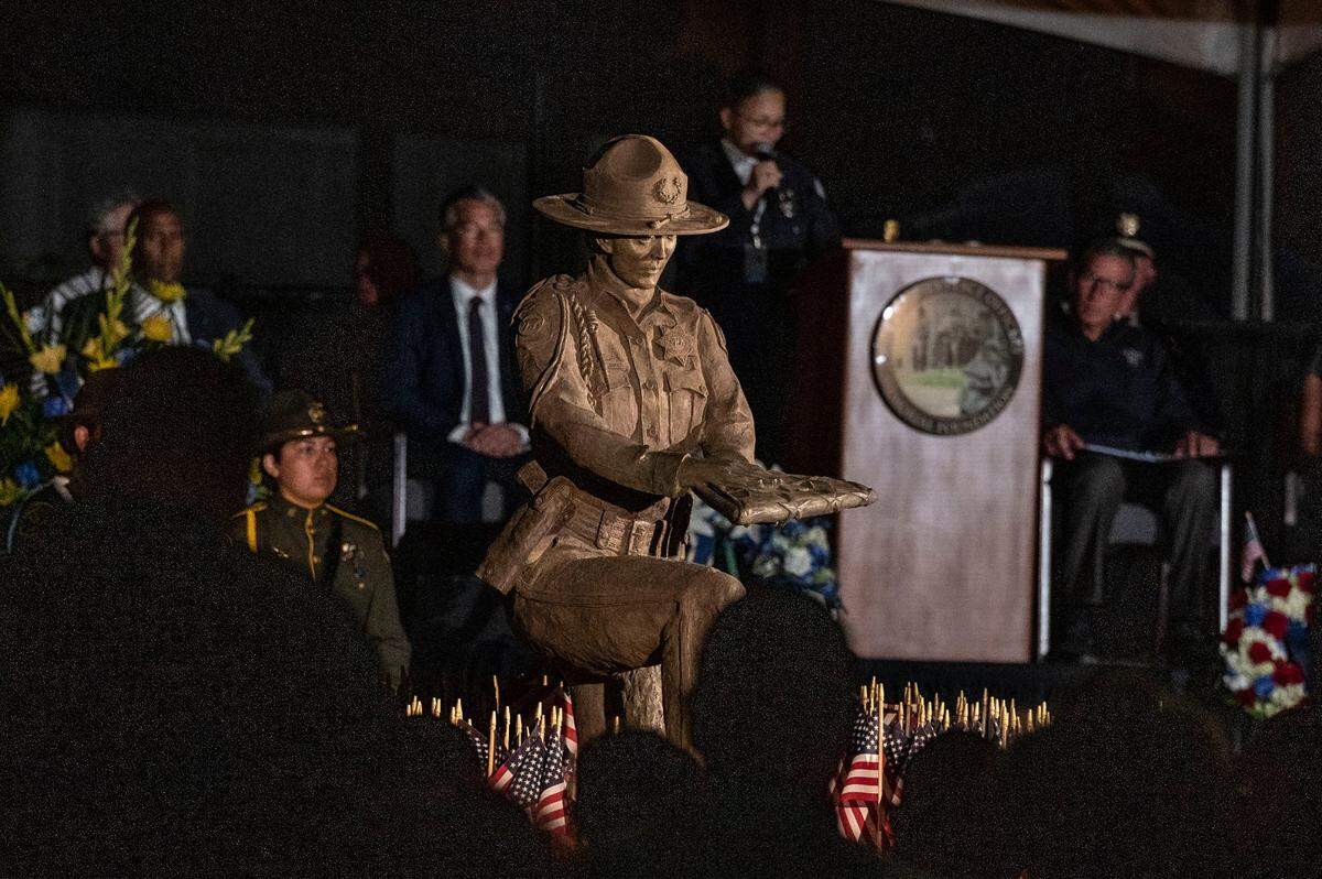 A statue honoring women in law enforcement is unveiled on Sunday, May 1, 2022, during a candlelight vigil the night before the annual ceremony to add names of fallen police officers to California Peace Officers Memorial at the state Capitol in Sacramento. The existing memorial statue had featured three men representing different eras of the state’s law enforcement history.
