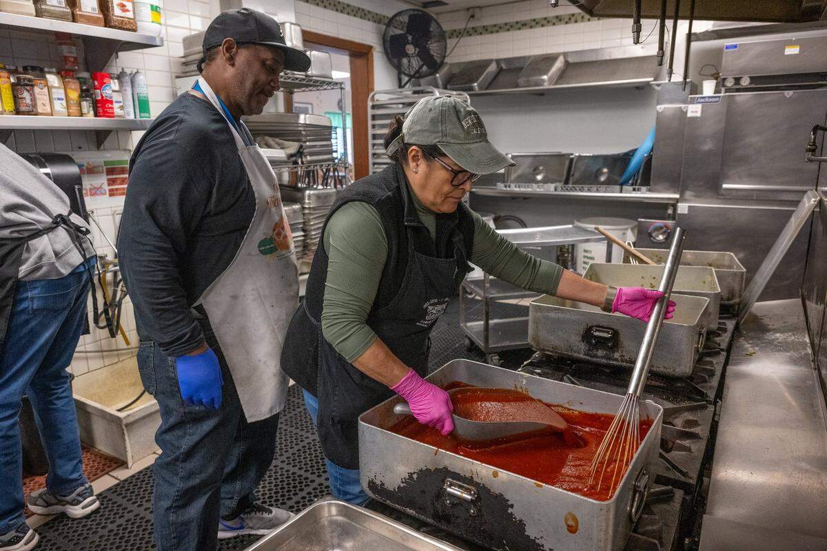 Chef Edwin Burton of Loaves & Fishes, left, looks on as volunteer Ja’net Blea cooks on one of the stoves that is working in November. The Sacramento nonprofit dedicated to feeding the hungry and sheltering the homeless is asking for new stoves.