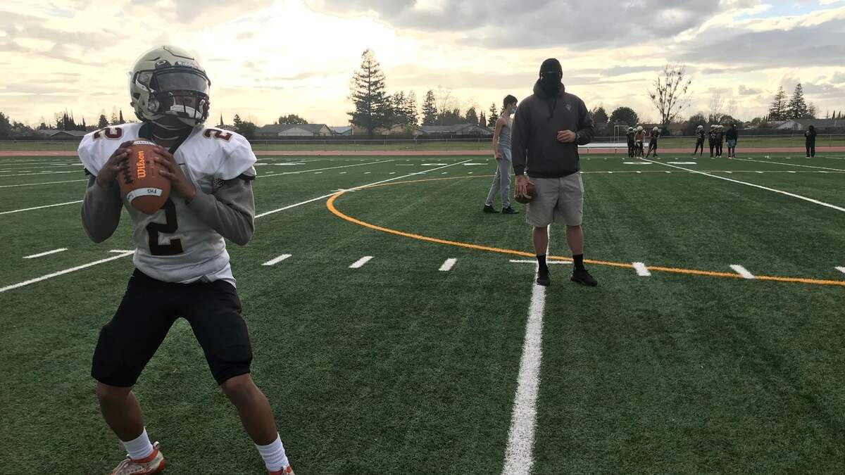 Florin quarterback Kavon Smith works on mechanics with assistant coach John Davis.