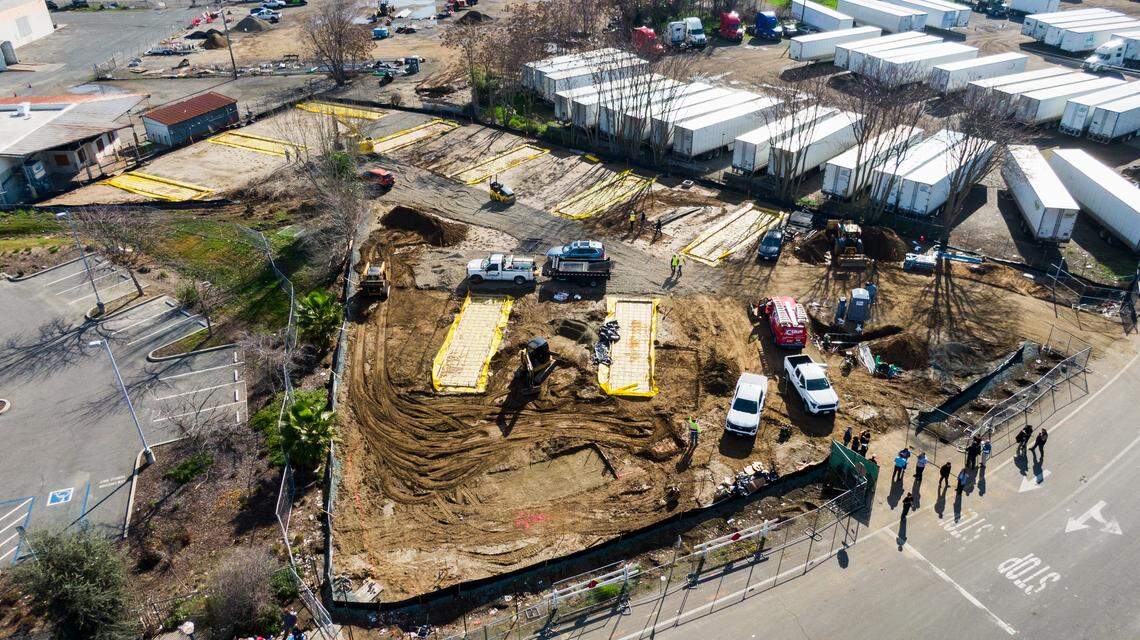 Workers build a new safe camping site for the homeless on Sequoia Pacific Boulevard in Sacramento’s River District on Friday.