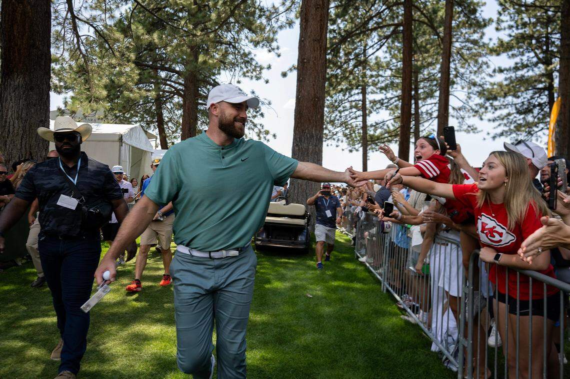 Travis Kelce reaches out to a fan as he makes his way to the 18th tee in the first round of the American Century celebrity golf championship on Friday, July 12, 2024, in Stateline, Nev.