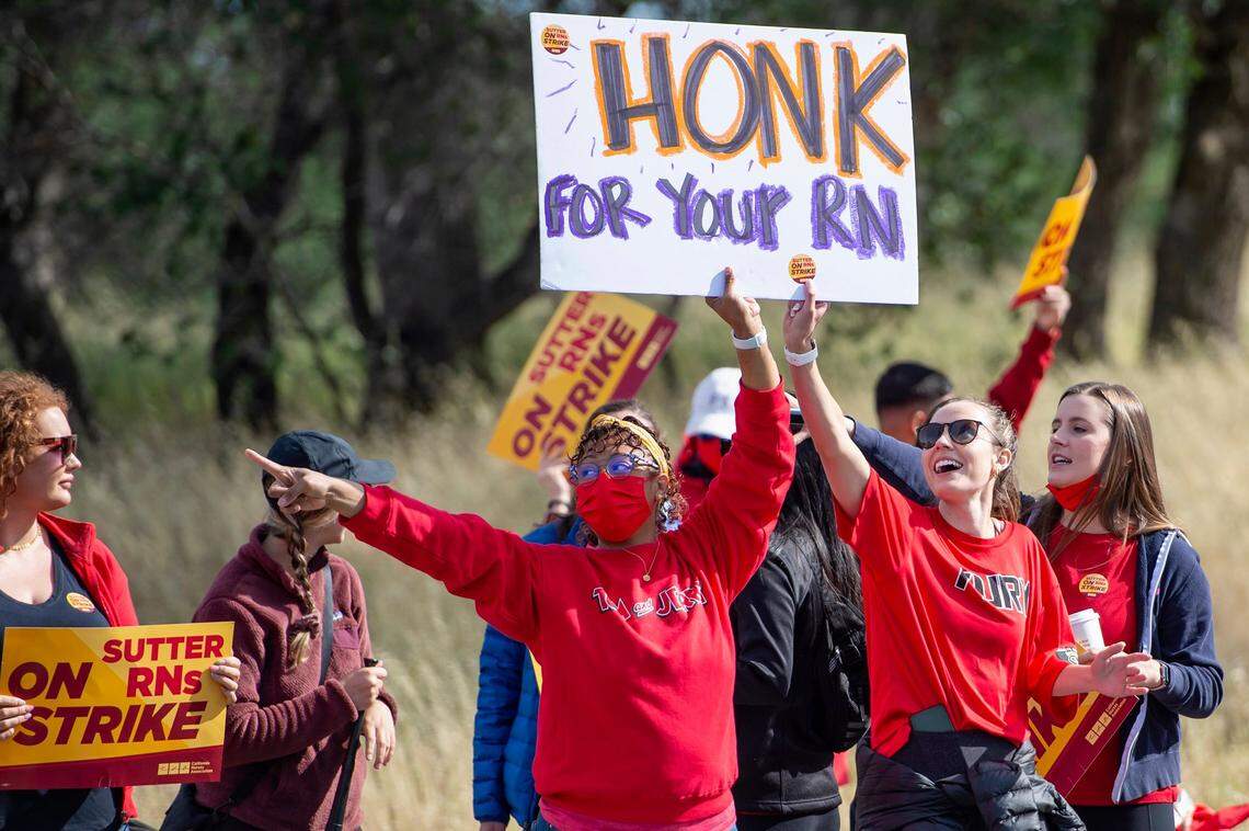 Registered nurses Domonique Harris, left, and Kathryn Foster, right, hold a sign while they strike with other nurses and healthcare workers of Sutter Roseville Medical Center at the intersection of North Sunrise Avenue and East Roseville Parkway on Monday. Strikes occurred at 15 Sutter facilities across Northern California.