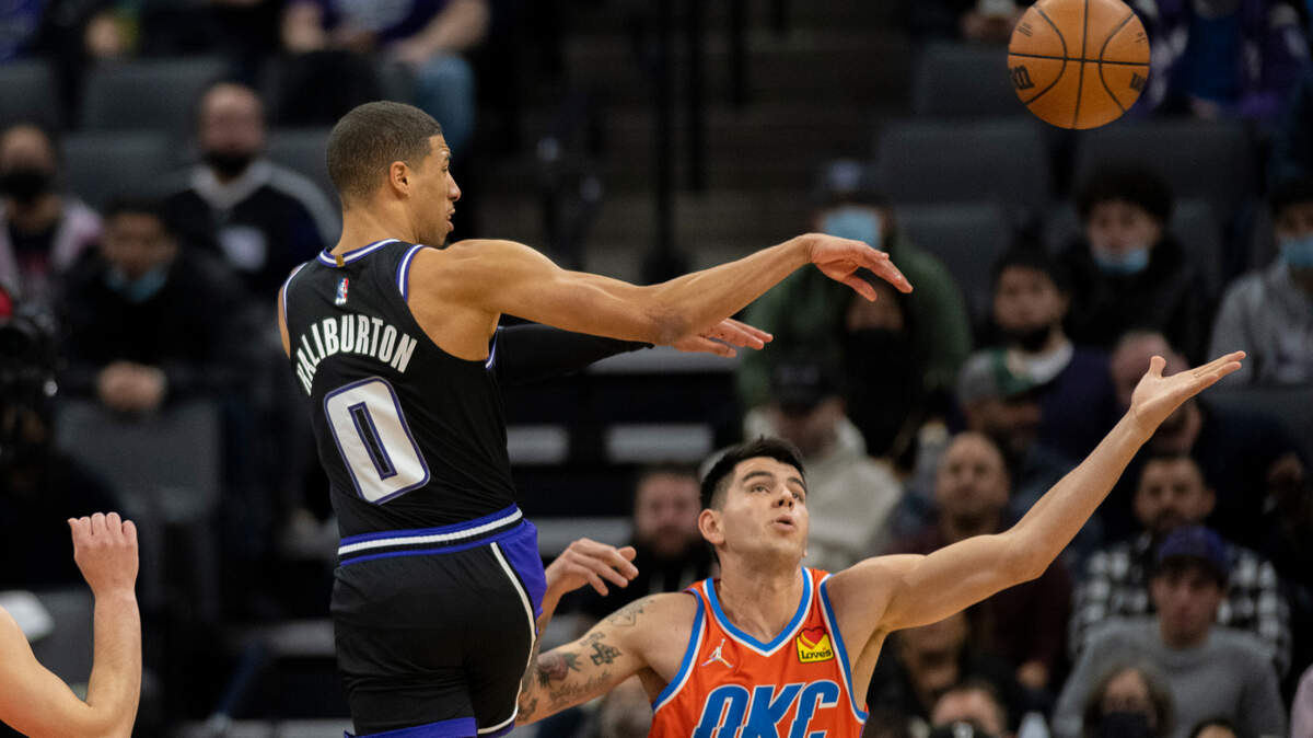 Sacramento Kings guard Tyrese Haliburton (0) passes past Oklahoma City Thunder forward Gabriel Deck (6) during the first quarter of an NBA basketball game in Sacramento, Calif., Tuesday, Dec. 28, 2021. (AP Photo/José Luis villegas)