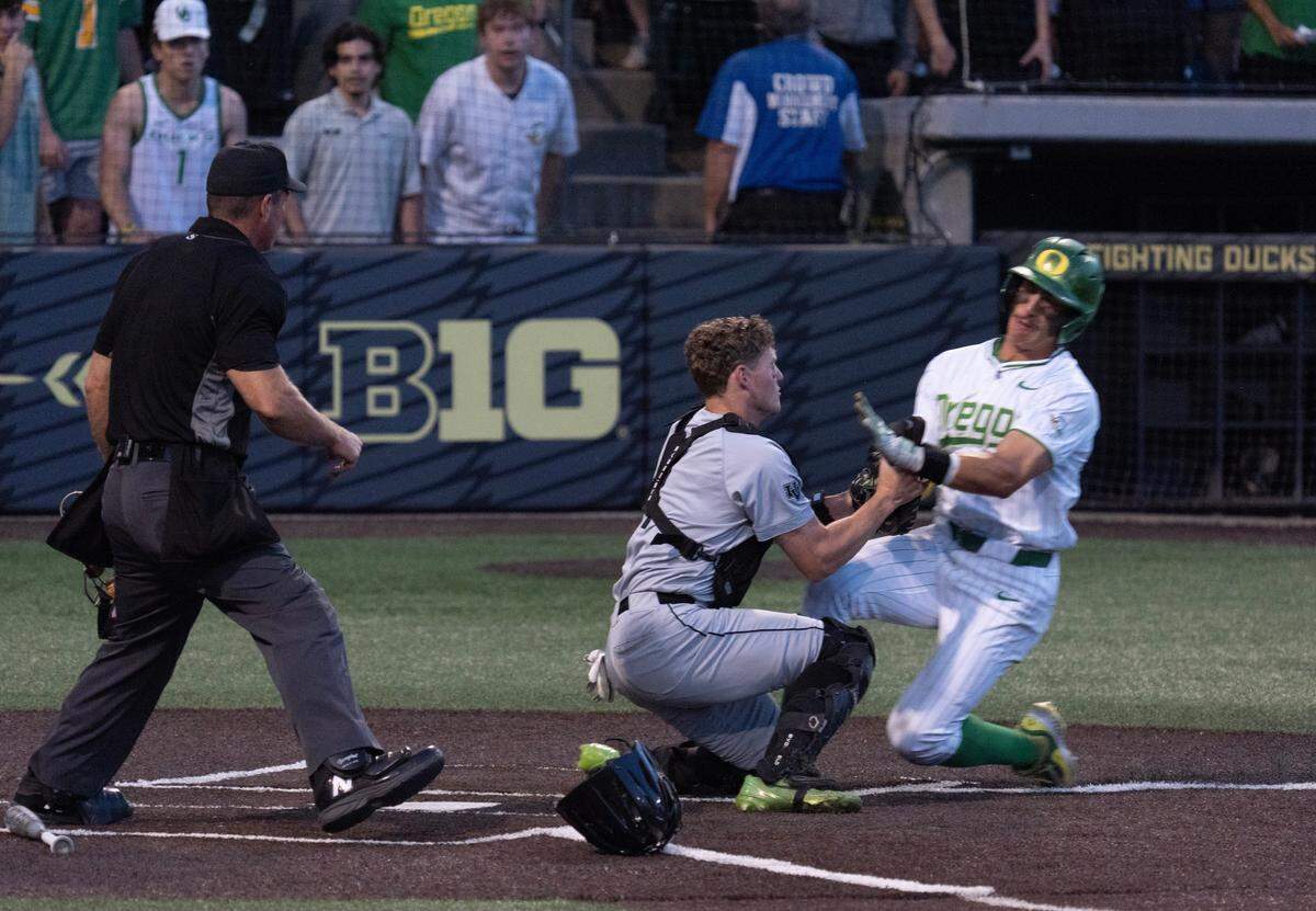 Oregon's Anson Aroz, right, slides into Utah Valley catcher Mason Strong at the plate in the eighth inning of the Eugene NCAA Regional at PK Park.