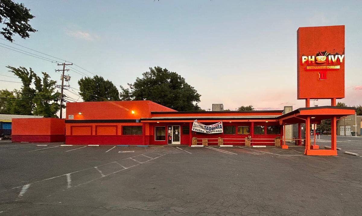 The former brick-and-mortar of Pho Ivy II at 501 Broadway in Sacramento is painted orange and red on Sunday, July 23, 2023. Los Inmortales Taqueria Cocina Mexicana, the new business moving into the space, hung a banner on the outside of building.