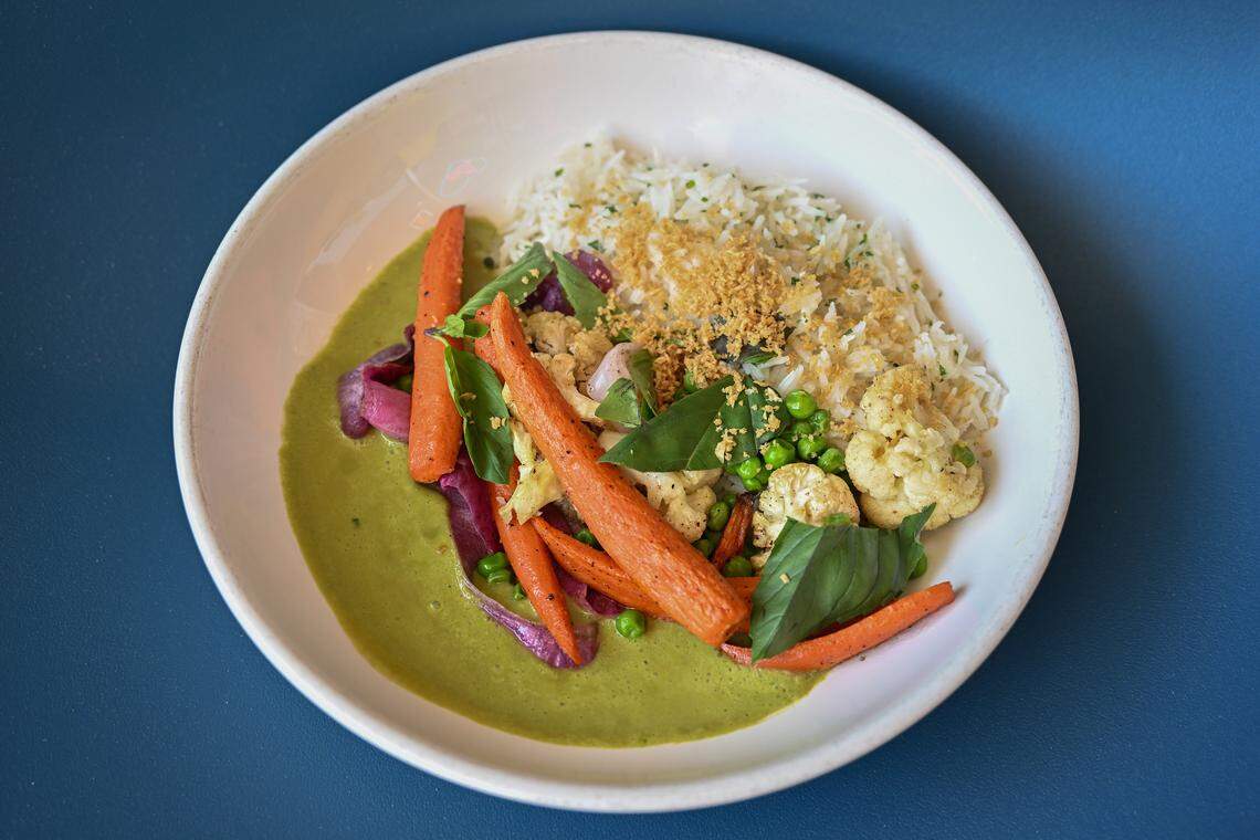 A plated favorite dish: Spring Thai Curry with cilantro rice, cauliflower, peas, carrots, red onion and toasted garlic is served at Mother.