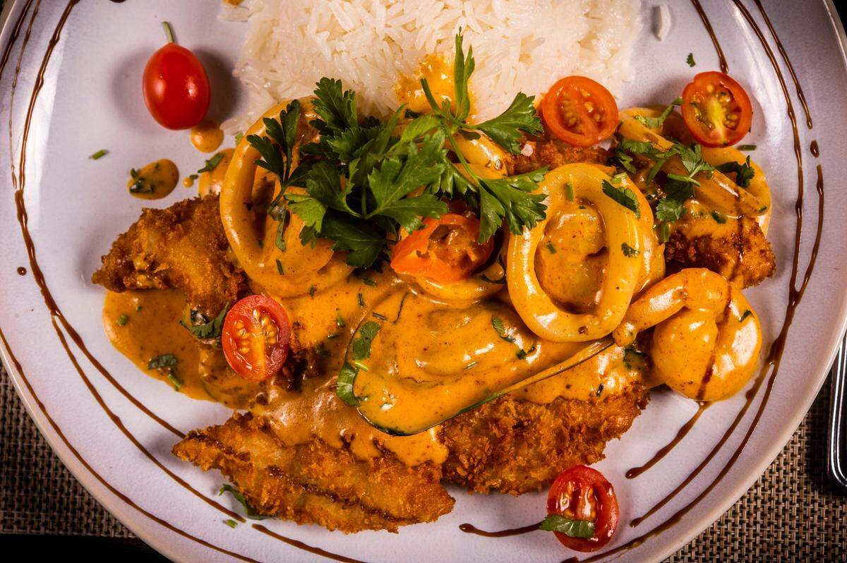Pescado a lo Macho, a pan-fried crispy white fish fillet topped with shrimp, calamari and muscles with garlic rice is an entrée at Chicha Peruvian Kitchen in Roseville.