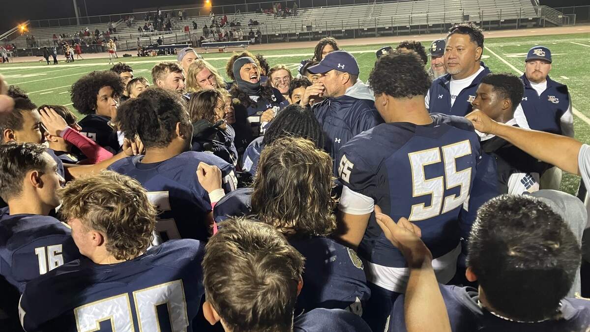 Elk Grove players and coaches gather together after a 35-21 win over Jesuit on Friday, Oct. 21, 2022.