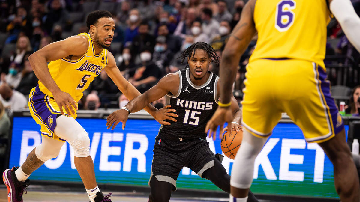 Sacramento Kings guard Davion Mitchell (15), right, dribbles past Los Angeles Lakers guard Talen Horton-Tucker (5) during the second period of the NBA basketball game Wednesday, Jan. 12, 2022, at Golden 1 Center in Sacramento.