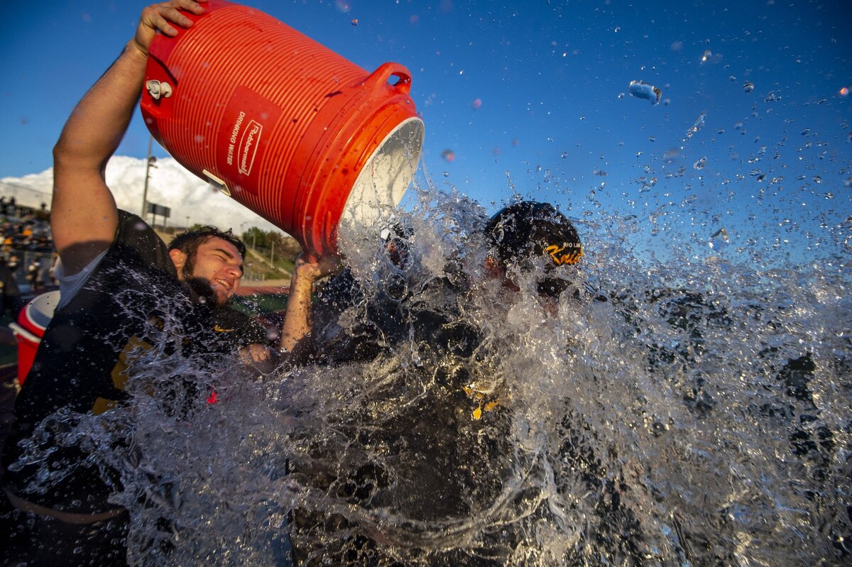 Former Rio Linda Knights football player Cameron Skattebo (5) pours water on Rio Linda Knights head coach Jack Garceau after their 63-14 victory over the Casa Roble High School Rams in the 2018 Sac-Joaquin Section Division IV championship game.