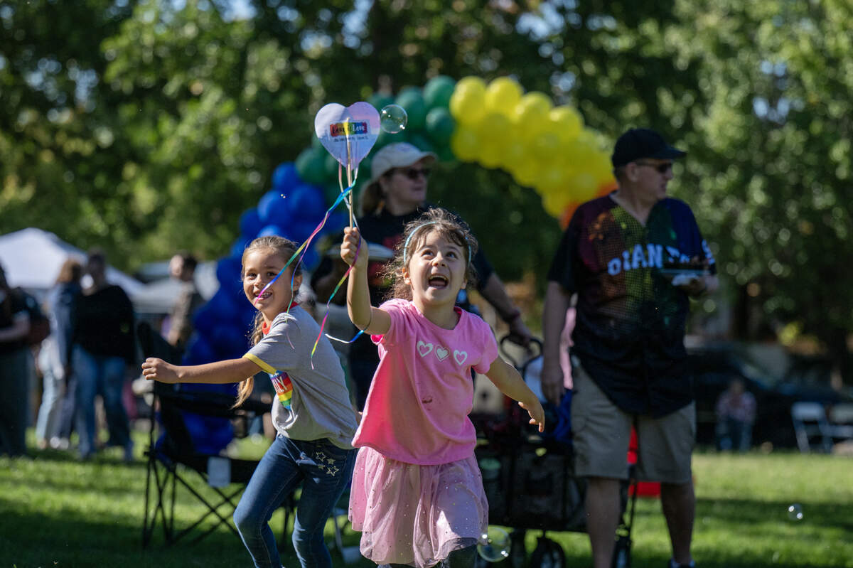 Abby Ross, center, and Jesse Lopez-Friedrichs chase bubbles at the inaugural Folsom Family Pride Celebration at Folsom City Lions Park on Saturday, Oct. 11, 2025.