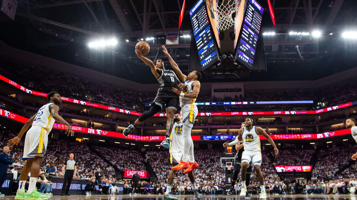 Sacramento Kings guard Malik Monk (0) goes up for a shot as Golden State Warriors guard Jordan Poole (3) defends during the first half of the first-round NBA basketball playoff series at Golden 1 Center on Saturday, April 15, 2023.