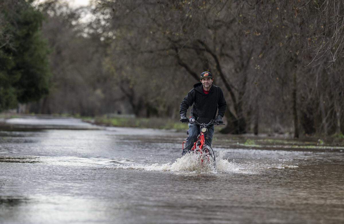 A bicyclist maneuvers the flooded trail on the Sacramento Northern Bikeway in Rio Linda on Friday, Dec. 26, 2025. 