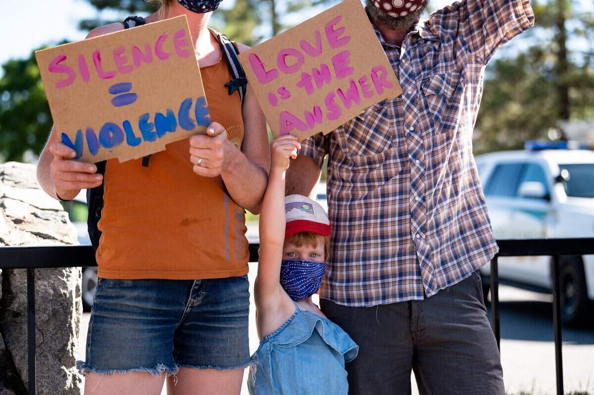 Protesters hold signs at a rally against racial injustice in Colfax on Wednesday.