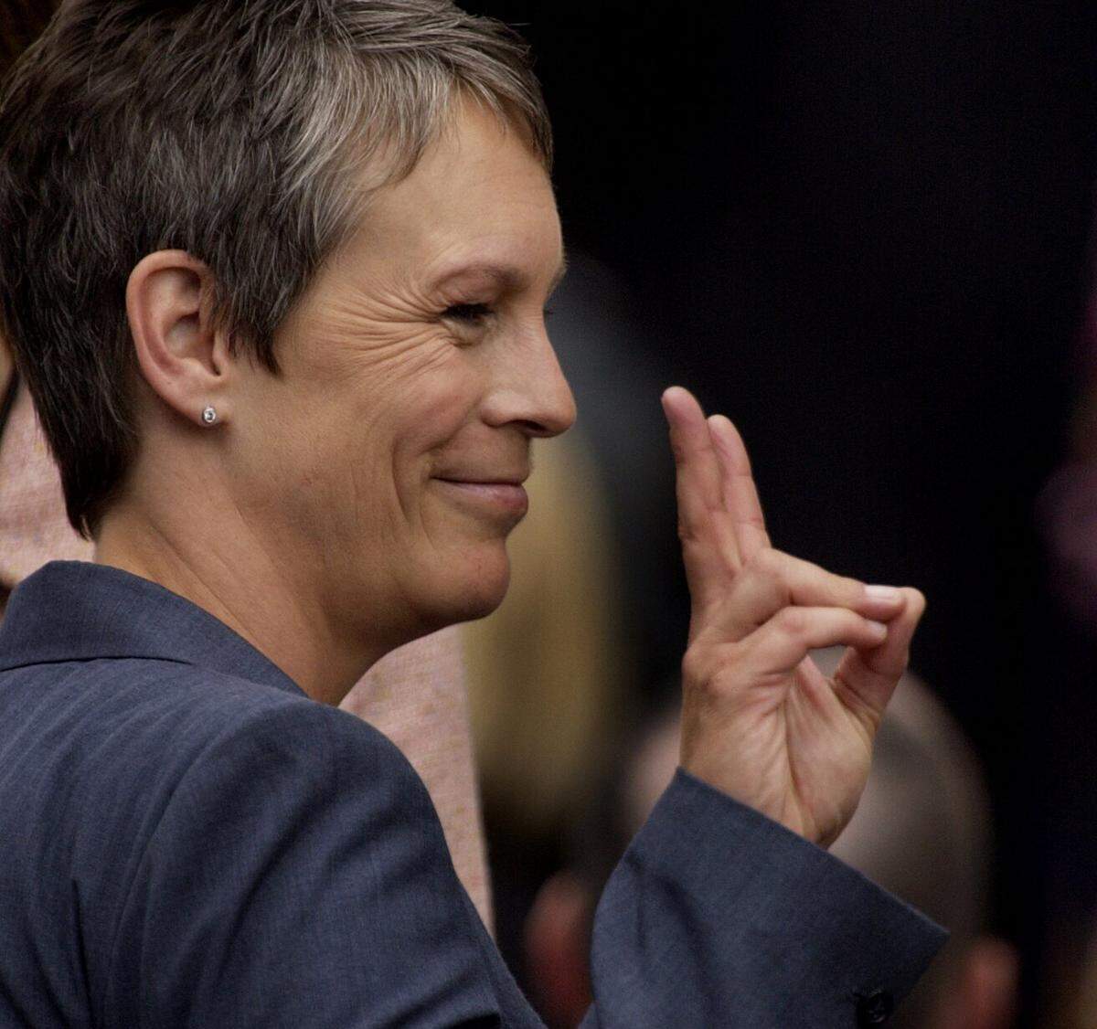 Film star Jamie Lee Curtis jokes around before the swearing in ceremony of Arnold Schwarzenegger on the steps of the state Capitol on Nov. 17, 2003. Curtis starred with Schwarzenegger in “True Lies.”