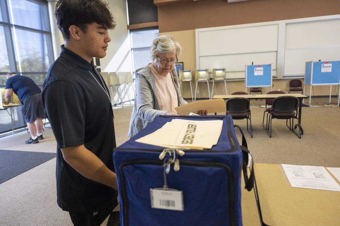 Irene Webb, of Folsom, inserts her ballot into the ballot "box" after voting on Proposition 50 at Folsom Lake College on Tuesday as a student election clerk observes. 