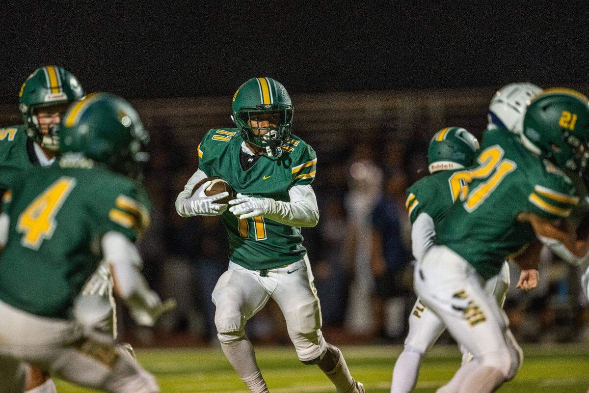 The Placer Hillmens’ Baylor Kelley (11) looks for a hole as he rushes against the Casa Roble Rams on Friday, Aug. 23, 2024, in Auburn during the season opener for both teams.